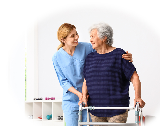 Caretaker helping elderly woman with walking frame indoors
